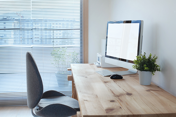 clean neat tidy simple desk with desktop computer with elegant window blinds